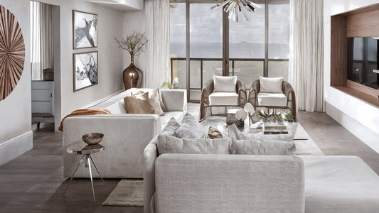 Bright, modern, and stylish living room with white sectional sofa and floor-to-ceiling windows, illustrating budget-friendly renovation ideas for luxury home decor.