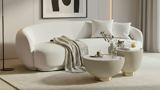 Janelle 213cm Curved Bouclé 3.5-Seater Sofa in Cream White, featuring plush throw pillows, a beige knitted blanket, and a solid wood frame, set in a minimalist living area.