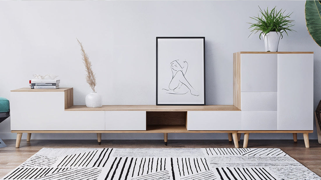 Modern living room with a white and black geometric rug placed beneath a wooden media console, illustrating a guide to the perfect rug placement for a space.