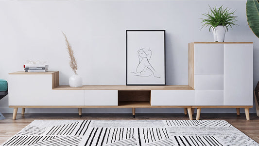 Modern living room with a white and black geometric rug placed beneath a wooden media console, illustrating a guide to the perfect rug placement for a space.
