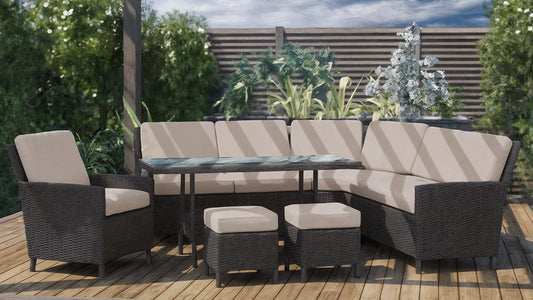 Wicker outdoor sectional lounge set with tan cushions and glass-top table on a wooden deck, perfect for enjoying Australia's sunny days with durable furniture.