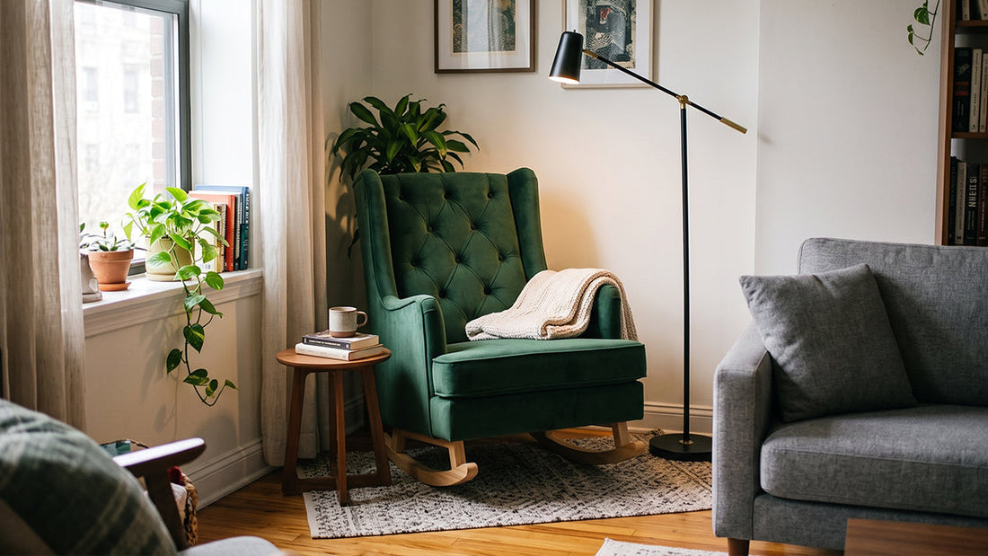 Emerald green tufted velvet rocking chair with a knitted throw blanket beside a wooden side table