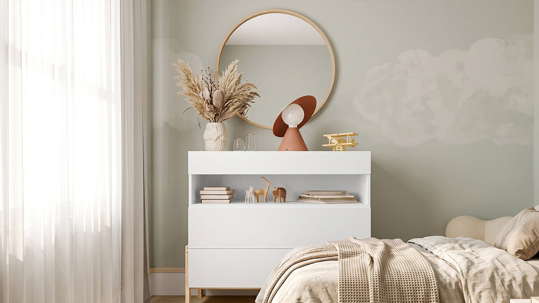 White storage cabinet with round mirror beside neutral bed