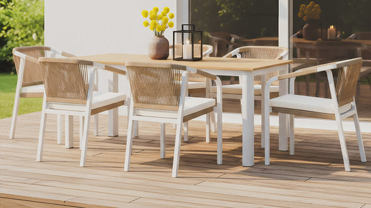 White outdoor dining set with woven chairs and timber table on deck