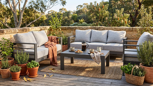 beautifully restored cast iron bistro set on a sun-drenched Australian terrace, styled with linen cushions and potted herbs