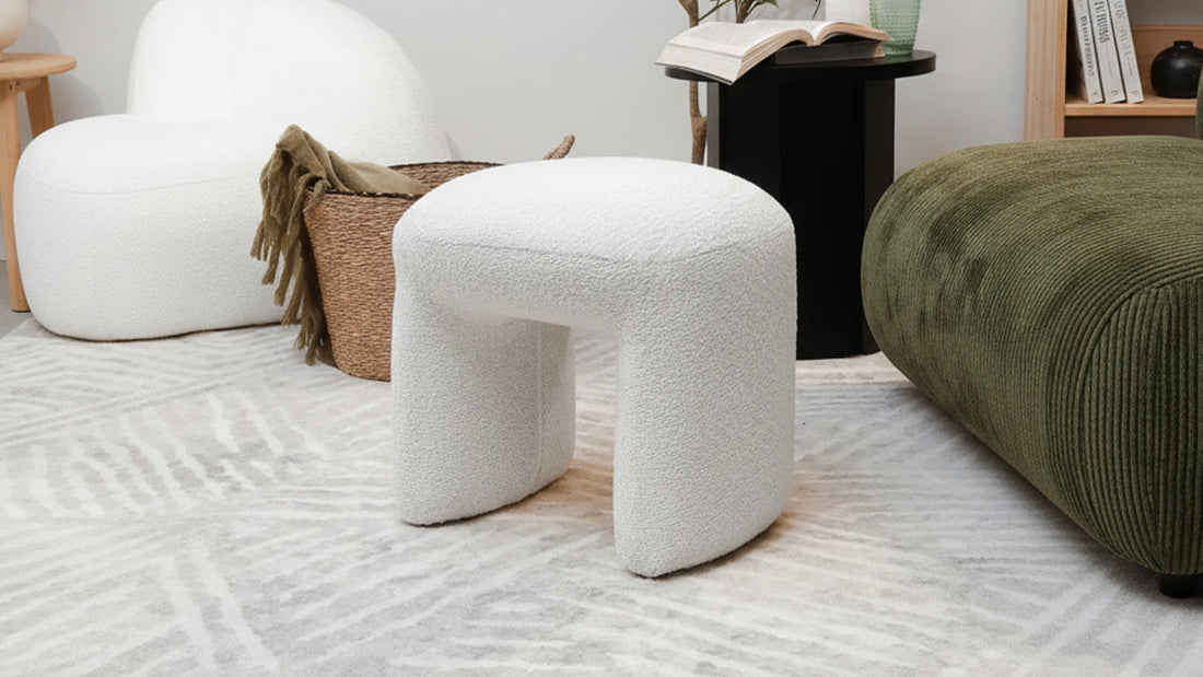 A white fuzzy ottoman in a modern living room.