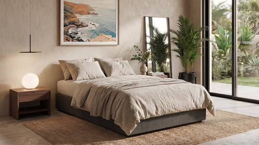 Grey fabric bed with neutral bedding in calm modern bedroom