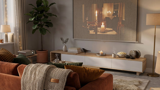 Comfortable home theater space styled with an orange velvet sofa, knit blanket, potted fiddle leaf fig tree, and a long Scandinavian entertainment unit.