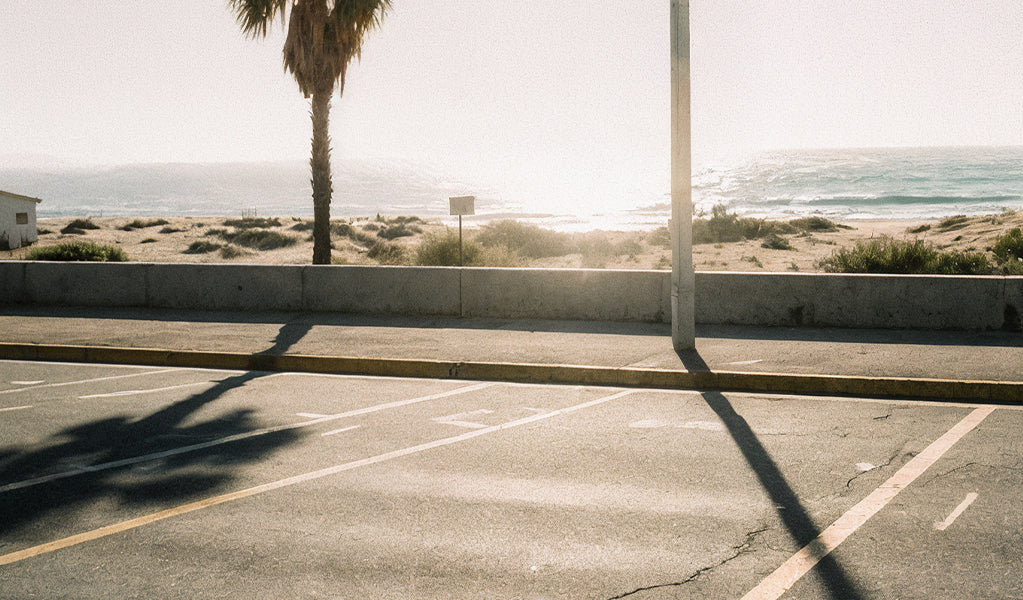 An empty beachside parking lot with a view of the ocean, highlighting the convenience of private parking in coastal areas.
