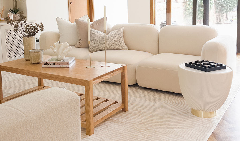 Airy Australian living room with a mid‑range neutral sofa, light oak coffee table and layered textures—illustrating the smart evolution approach to furniture.