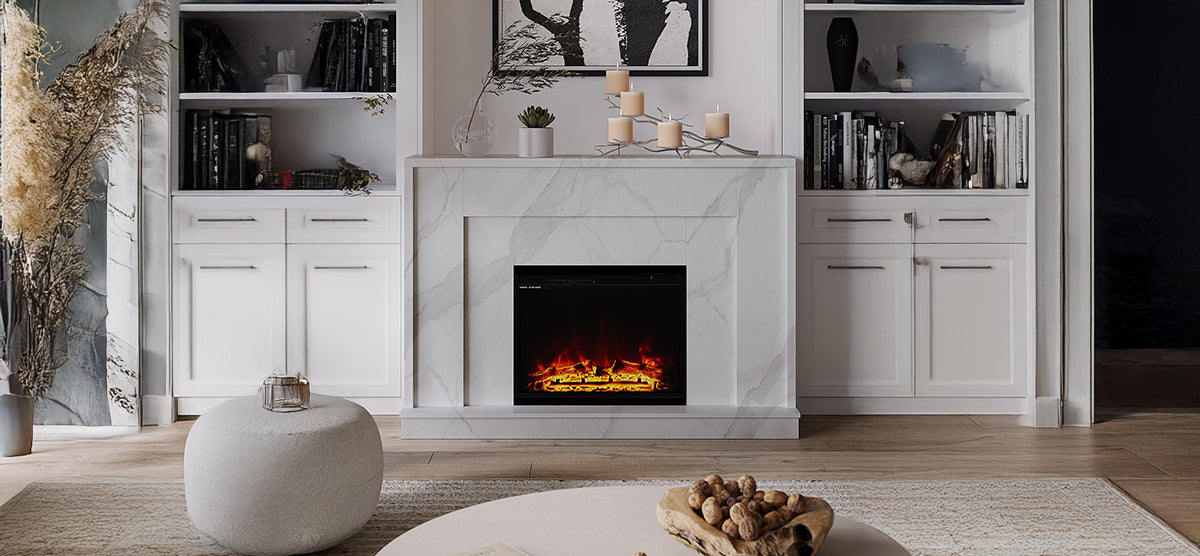 Elegant living room corner with a white marble fireplace, electric firebox, built-in shelves, abstract artwork, pillar candles, succulent, leafy vase, and a cream pouf.