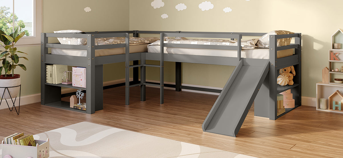 Children's playroom with gray L-shaped loft bed, featuring twin mattresses, guardrails, slide, open shelves with books and toys, leafy plant, play rug, and a window.