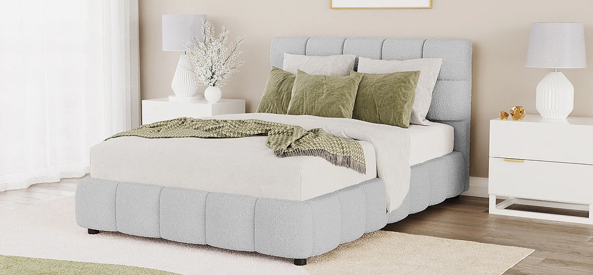 Contemporary bedroom with a low-profile upholstered bed featuring a tufted headboard, olive-green accents, flanked by white nightstands with sculptural lamps, on warm wood flooring.
