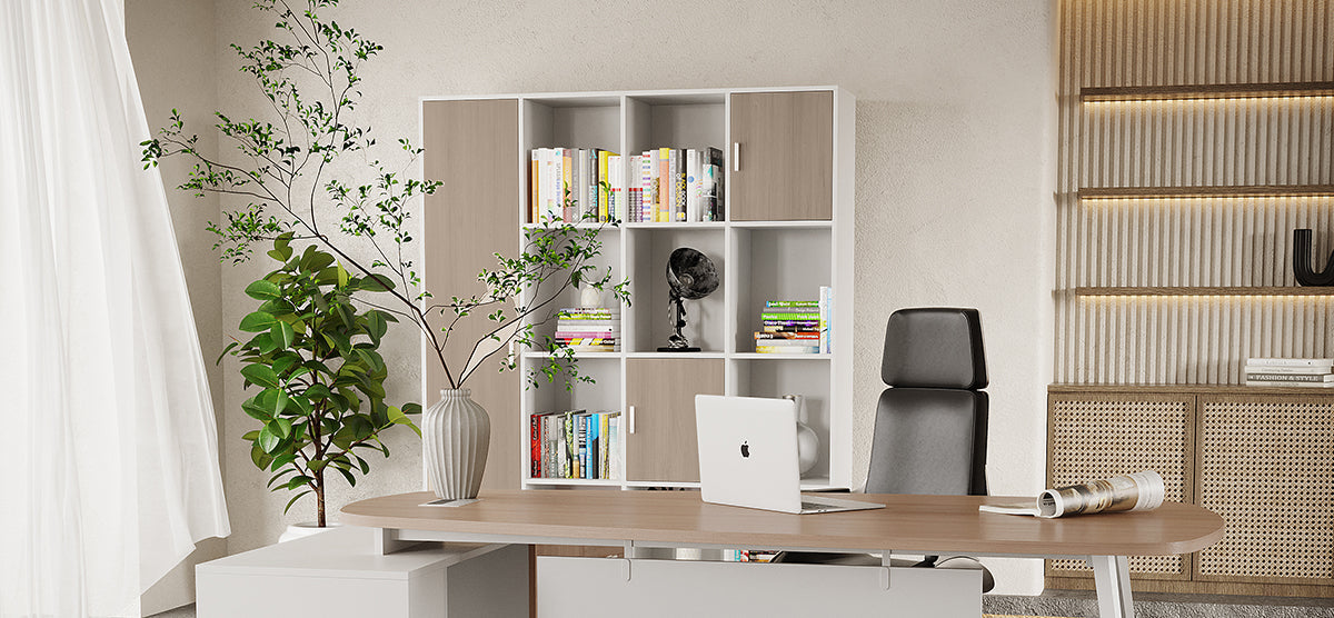 A modern home-office with a light wood desk, open laptop, sculptural vase, tall shelving unit, black office chair, rattan cabinets, and sheer curtains illuminated by natural light.