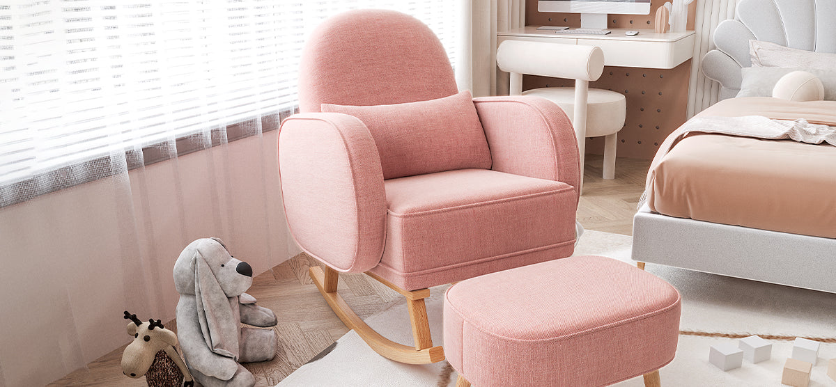 Pastel-toned nursery corner with a pink rocking armchair, matching ottoman, stuffed bunny and giraffe, herringbone floor, cream rug, peach bedding, and pale wood desk.