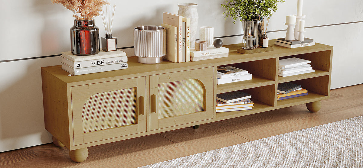 Scandinavian-style light-wood console with cane-front doors and open shelves, displaying books, a vase with dried grasses, a plant, candles, and decor on top.