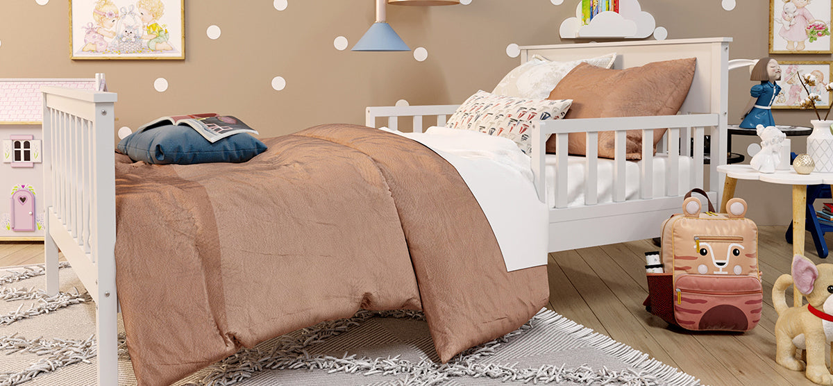 Child’s bedroom with a white wooden toddler bed featuring rust-brown bedding. Nearby, a side table with decor, a cloud shelf, animal backpack, and a dollhouse complete the cozy setup.