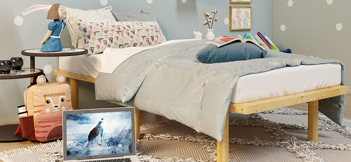 Cozy child's bedroom with a light-wood bed, blue/gray bedding, rabbit-ear figurine on side table, animal-face backpack, laptop with fantasy wallpaper, and polka-dot wall decor.