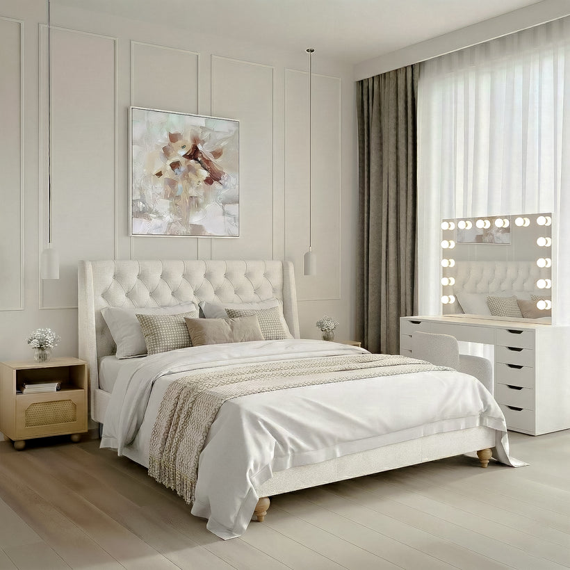 Bright modern living room with a curved cream sofa, two dark upholstered accent chairs, a sculptural wooden coffee table, soft neutral rug, sheer floor-to-ceiling curtains, abstract wall art, and a curved staircase illuminated by natural sunlight