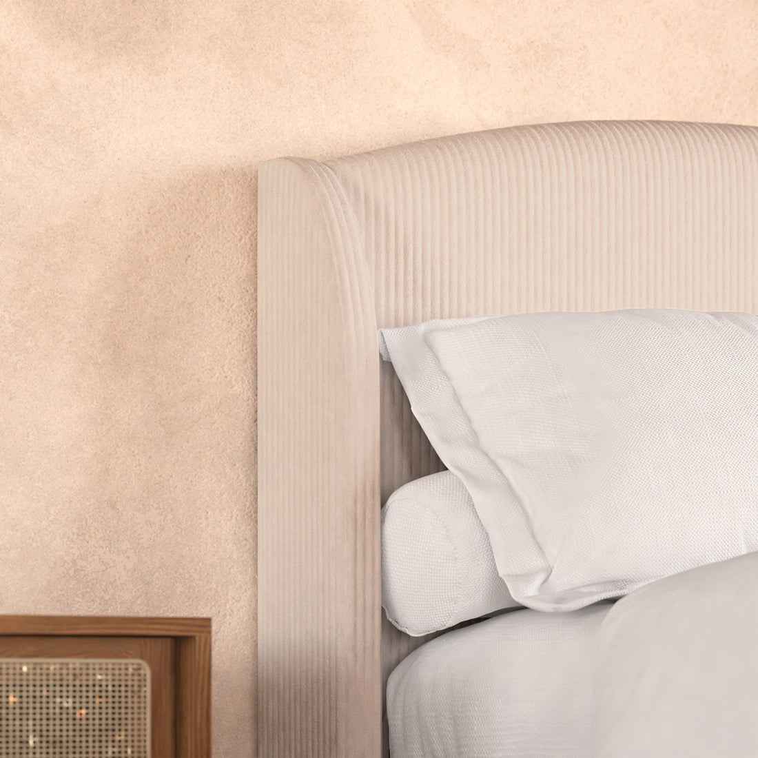 Aetiusa King Fabric Hardwood Bed Frame in Beige features a rounded, corduroy-upholstered headboard with white linens. A wooden nightstand with a woven cane front completes the cozy, textured bedroom setup.
