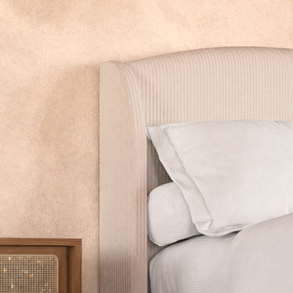Aetiusa King Fabric Hardwood Bed Frame in Beige features a rounded, corduroy-upholstered headboard with white linens. A wooden nightstand with a woven cane front completes the cozy, textured bedroom setup.