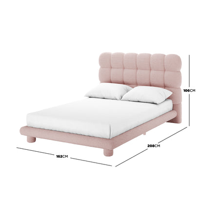 Aina Double Bouclé Bed Frame in Pink featuring a low-profile design with a tufted headboard and frame, upholstered in pink bouclé fabric, dressed in a white fitted sheet with two pillows. Dimensions included.