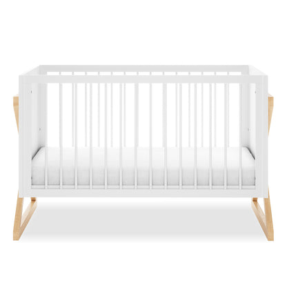 Aldwin Pine Adjustable Baby Cot - White/Natural, featuring white slatted side panels and a simple white mattress, supported by light-wood X-leg base, showcasing a modern and functional design.
