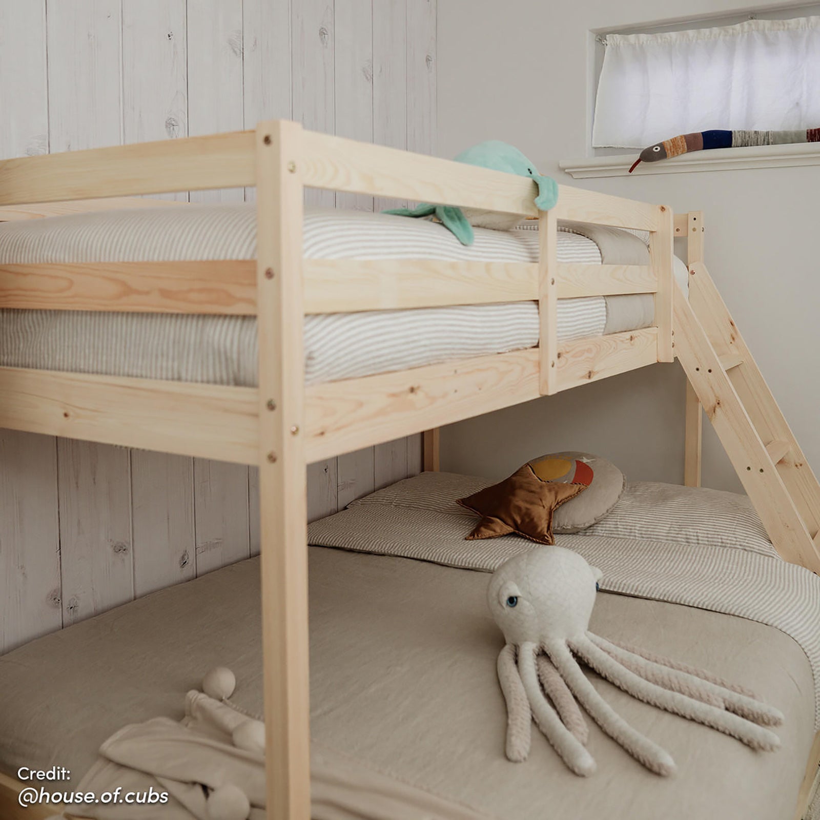 Antonia Wooden Triple Bunk Bed - Natural displayed in a cozy room setting, highlighting its solid pine frame and triple bunk configuration with a double bottom and single top bunk.