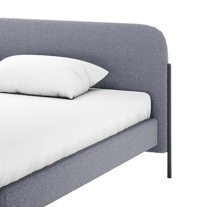 Bonny King Boucle Bed Frame in Grey featuring a textured gray fabric headboard, side rails, white fitted sheet, pillow, and slender black metal leg supports, showcasing modern elegance and craftsmanship.