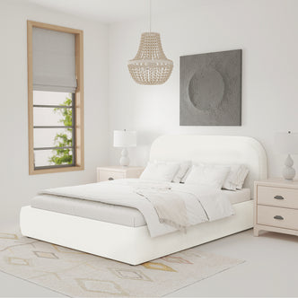Calix Queen Boucle Bed Frame in Cream White with low-profile design, upholstered in boucle fabric, features a rounded headboard and sits on a subtly patterned area rug with matching nightstands.