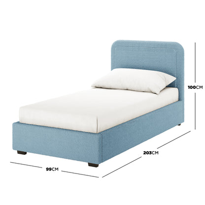 Carya Kids Single Fabric Bouclé Bed Frame in Blue, fully upholstered with a foam-padded headboard, shown with a mattress and pillow for scale. Dimensions: 99 cm wide, 203 cm long, 100 cm tall.