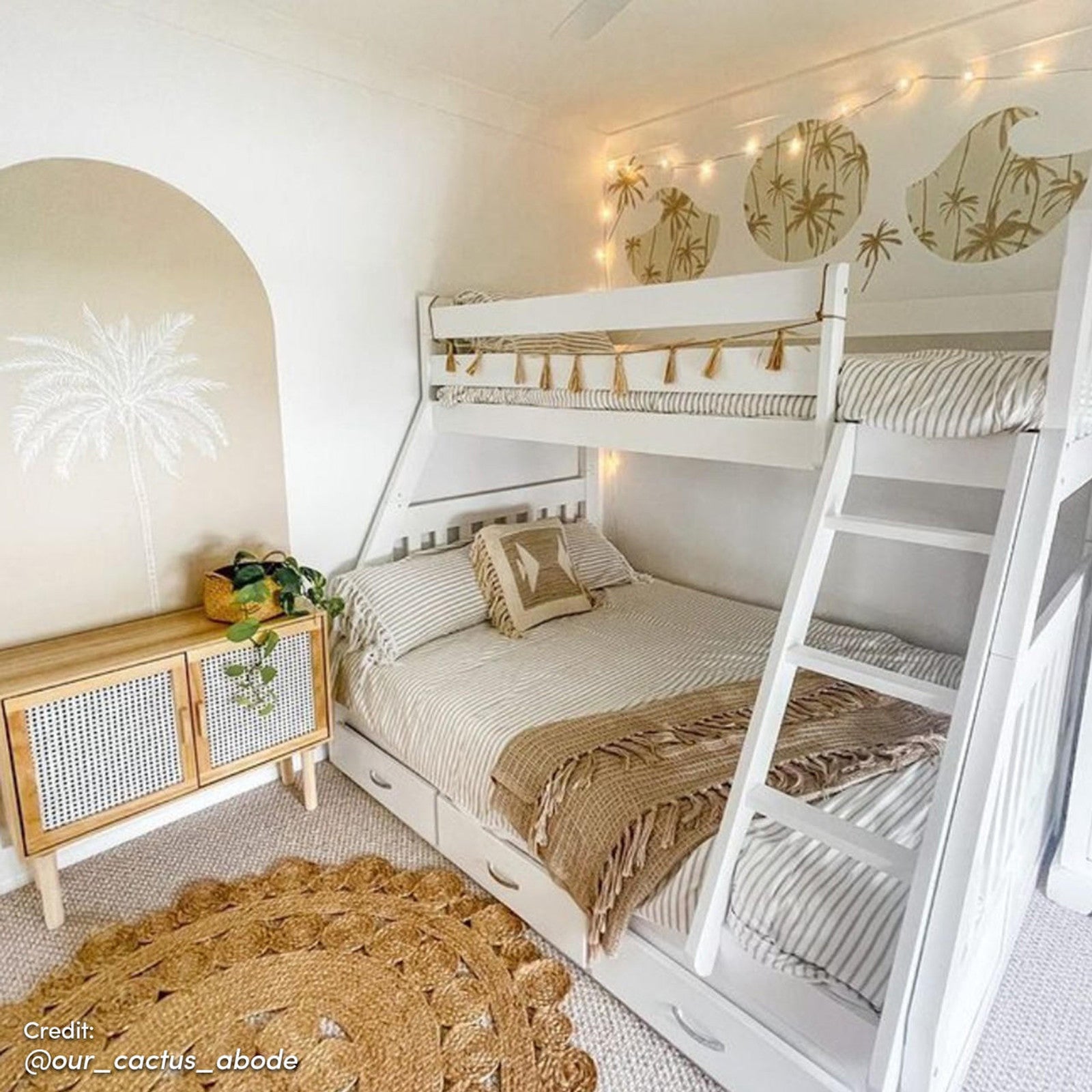 Cornelia Storage Triple Bunk Bed - White Solid Wood, featuring a single over double design with integrated storage drawers, sturdy ladder, and safety rails, set in a stylishly decorated room.