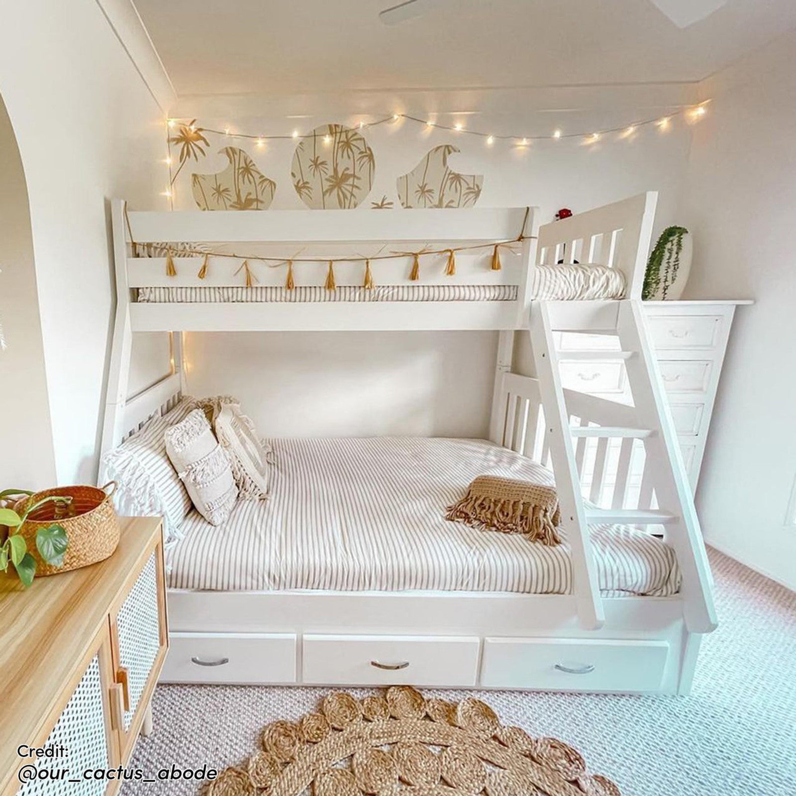 Cornelia Storage Triple Bunk Bed - White Solid Wood: A sleek triple bunk bed with guard rails, a solid ladder, and three under-bed drawers, providing practical storage in a compact, stylish design.