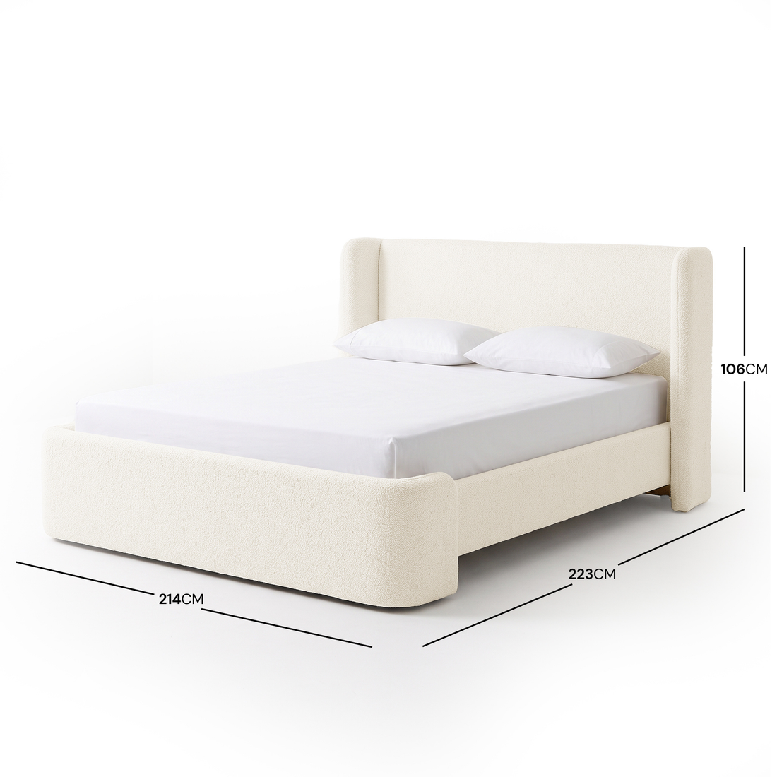 A white bouclé bed frame with a high winged headboard, curved footboard, and white bedding, shown with dimension measurements of 214cm width, 223cm length, and 106cm height on a white background.