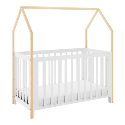 Damaris Solid Pine Baby Cot Bed in white and natural wood, featuring a house-shaped frame with slatted sides, and a mattress inside, blending style and functionality for a cosy nursery space.