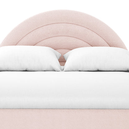 The Estilla Double Rainbow Boucle Bed Frame showcases a rounded, arch-style blush-pink headboard with concentric stitching, complemented by white pillows and bedding, offering a charming and cozy children’s bedroom upgrade.