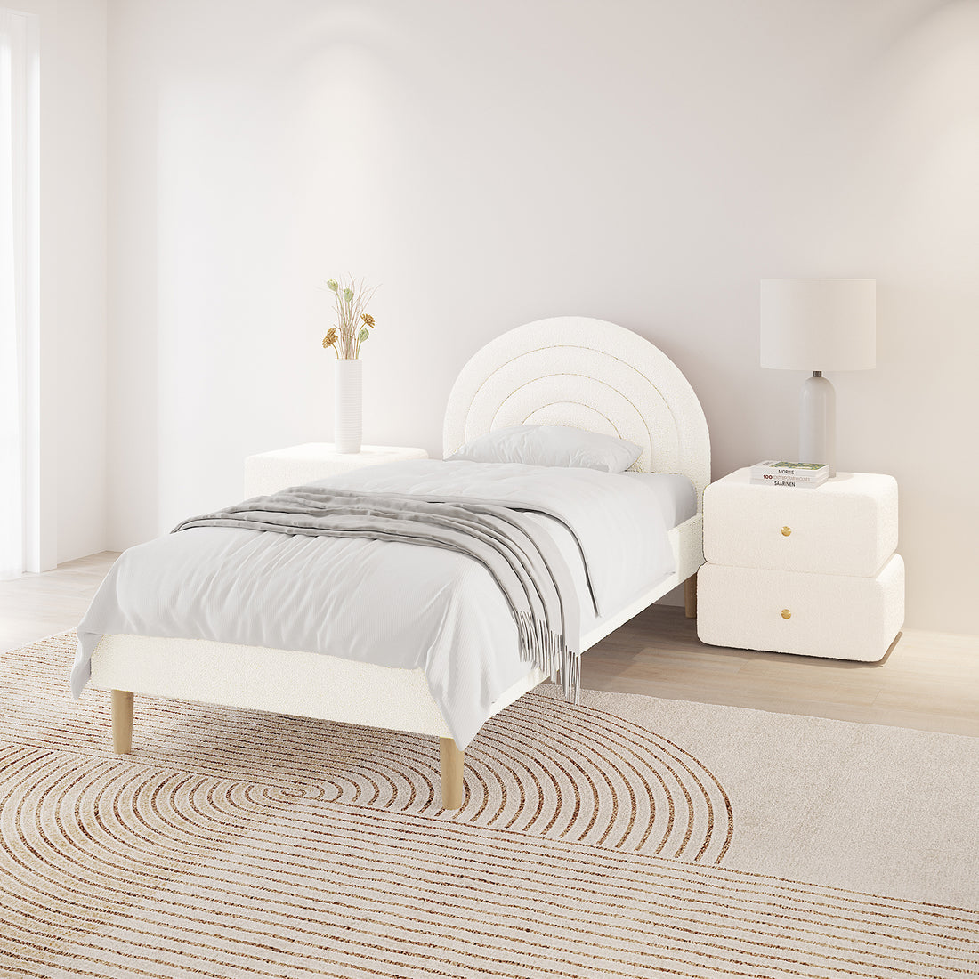 Estilla Single Rainbow Boucle Bed Frame in Cream White features a rounded headboard, crisp white bedding, light wood legs, and matching nightstands with a vase and lamp, set on a neutral rug.