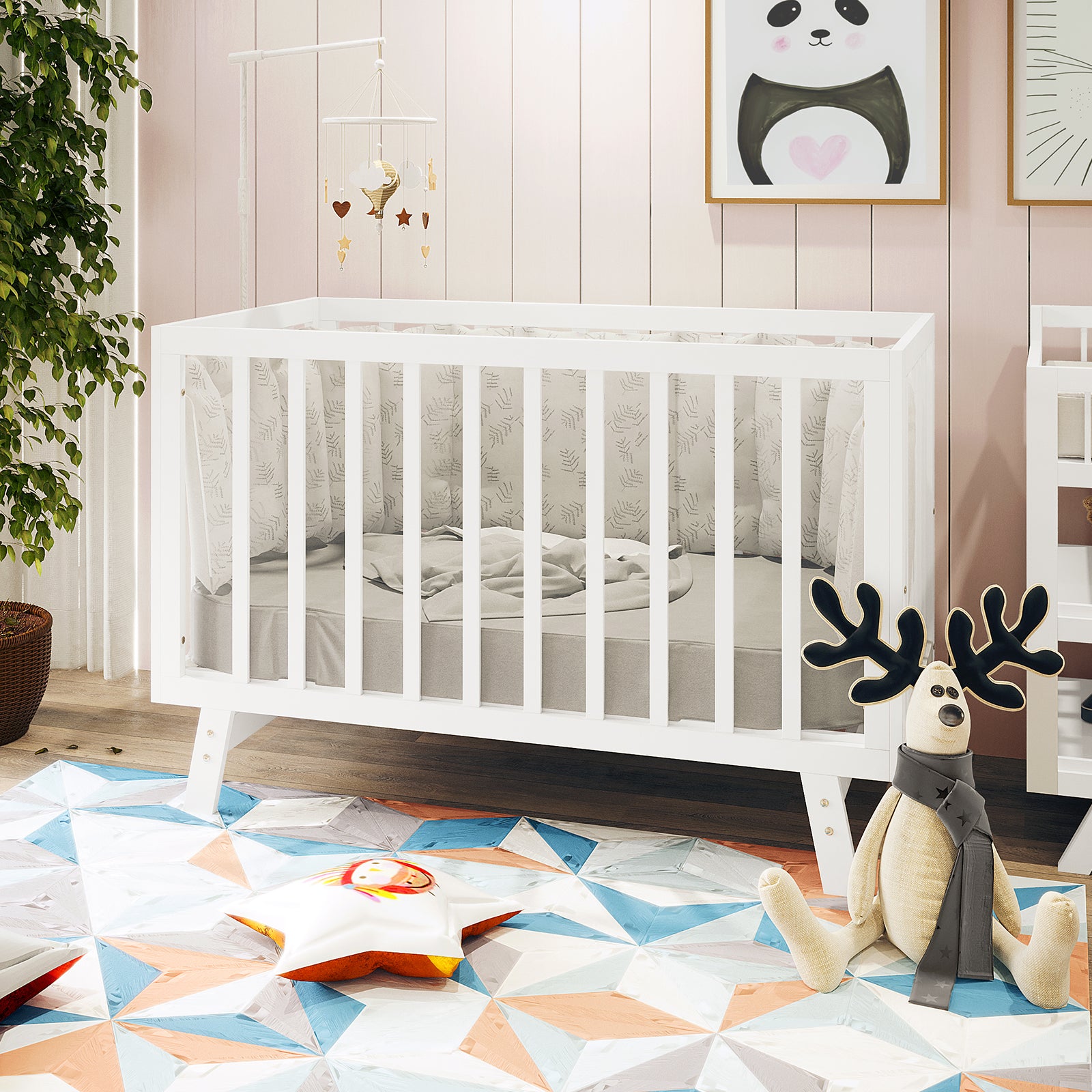 Eudora Classic Solid Wood Baby Cot in White with adjustable heights, features crisp lines, and pale-grey patterned bumpers, surrounded by modern nursery decor including a geometric rug and hanging mobile.