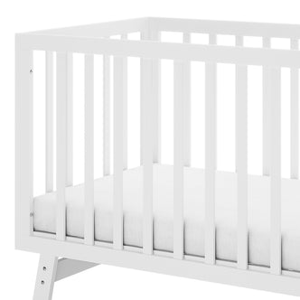 Eudora Classic Solid Pine Adjustable Nursery Cot – White, features a simple white wooden frame with vertical slats and a thin mattress, showcasing its timeless design and sturdy construction.