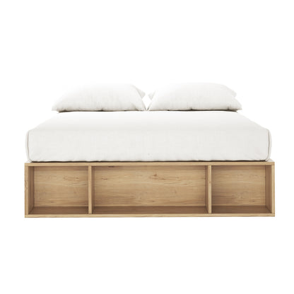 Eulalia Double Storage Platform Bed Base with Drawer in Oak features a minimalist design with a light-wood base and three open storage cubbies at the footboard, topped with a white mattress and pillows.