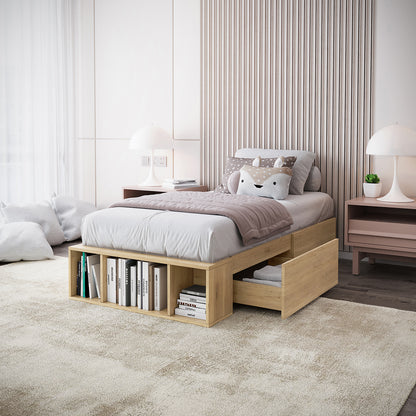 Eulalia Single Storage Platform Bed Base with Drawer in Oak, featuring open cubby shelving at footboard, a half-open under-bed drawer with linens, and a light wood frame in a minimalist bedroom.