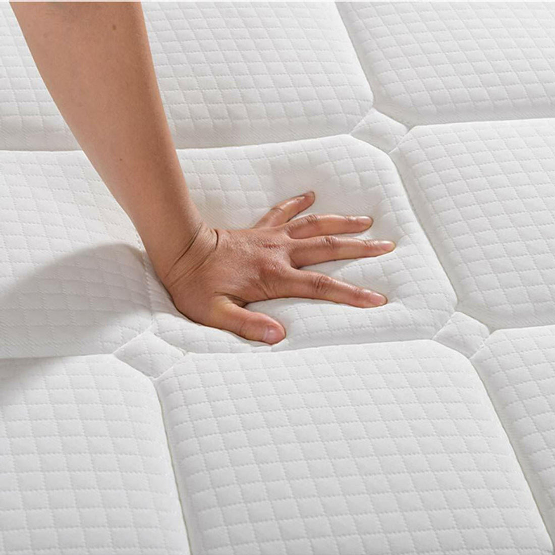 A hand presses into the quilted surface of a Venus mattress, part of the Aristos & Venus Bunk Bed & Mattress Package, illustrating the memory foam's cushioning and indentation.
