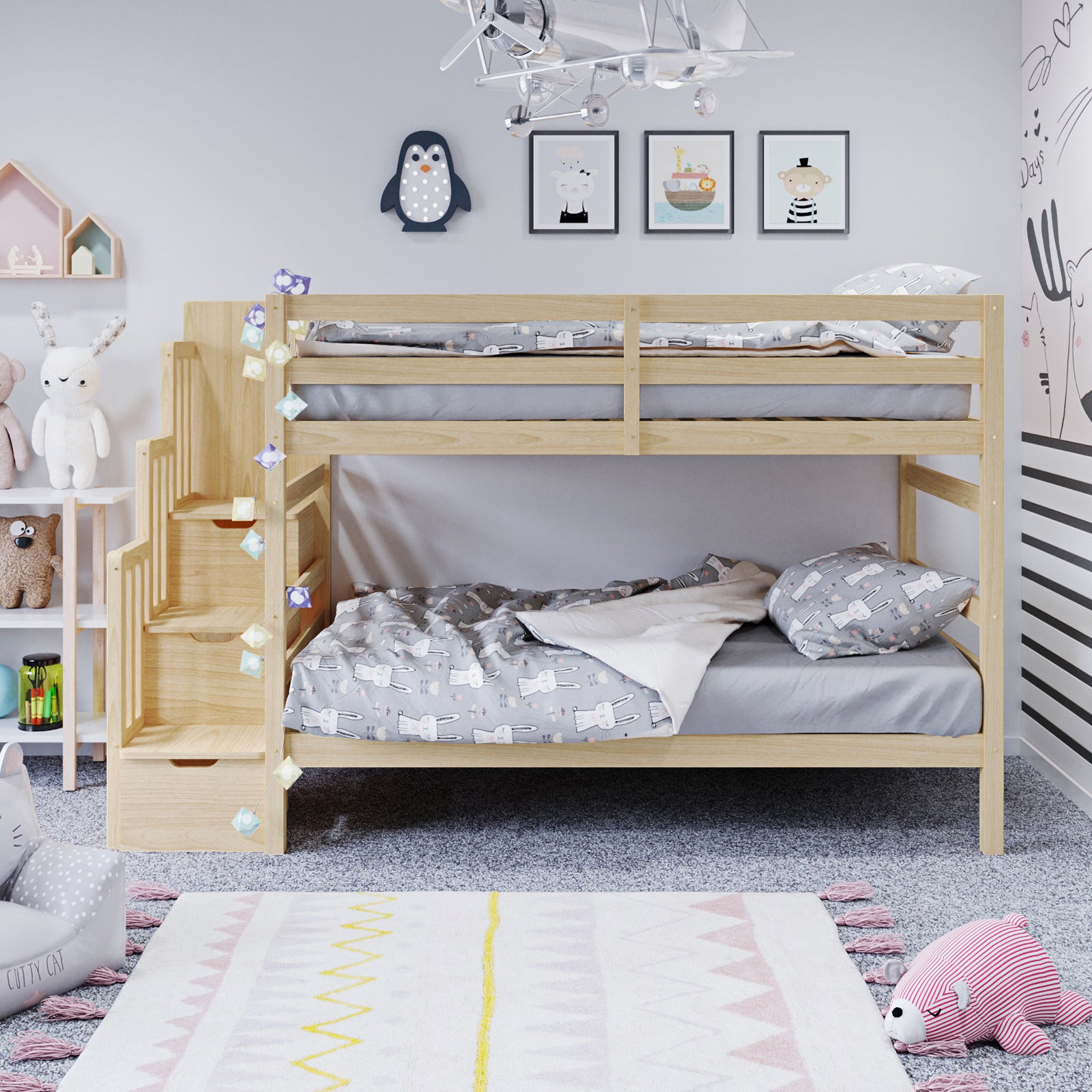 Galla Staircase Storage Bunk Bed - Natural Solid Wood with integrated staircase drawers and side shelves, visible in a child's room alongside a monkey picture and stuffed animal, showcasing its space-saving design.