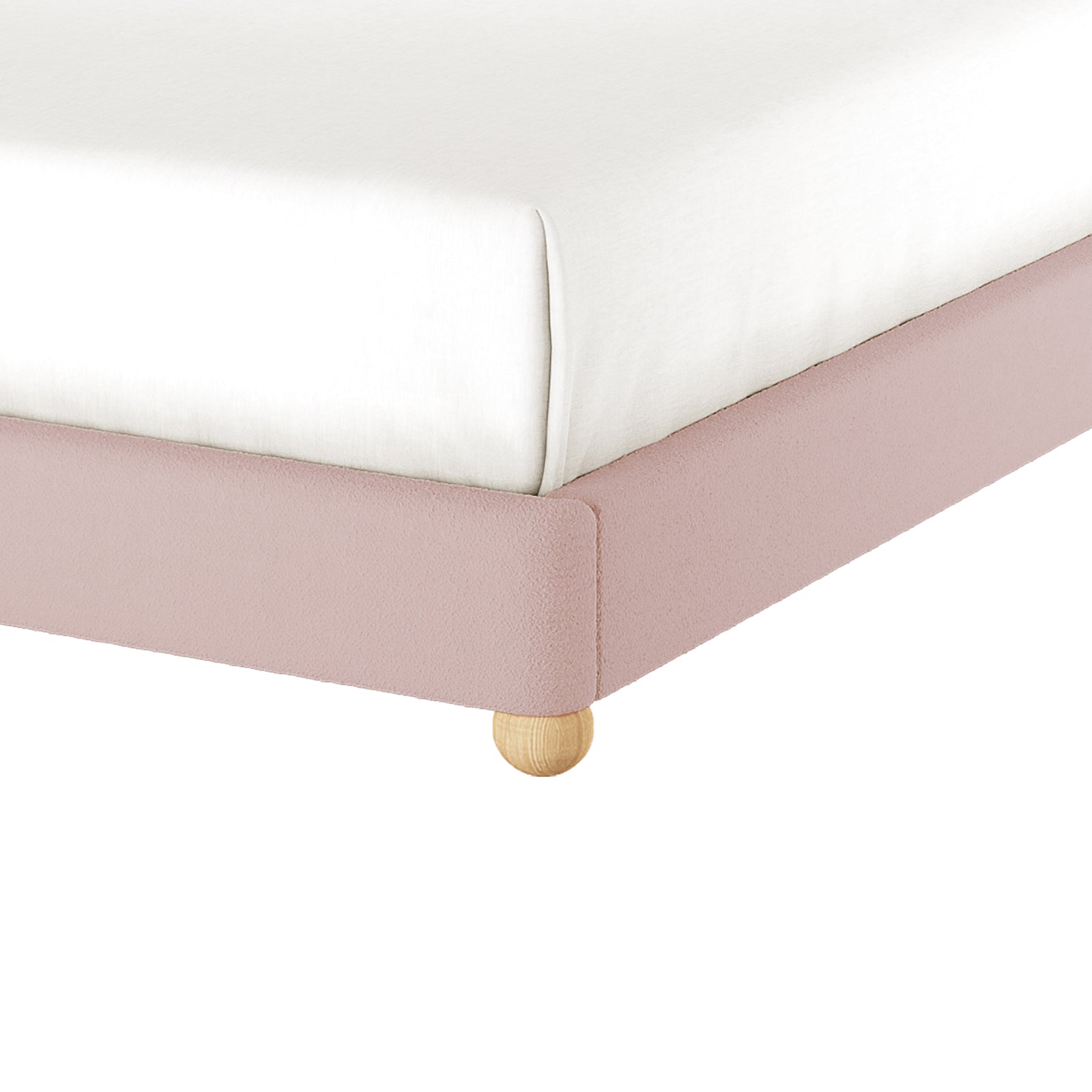 Close-up of the Ginnie Double Curved Bouclé Cloud Bed Frame in Pink, featuring blush-pink bouclé fabric, a white fitted sheet on top, and a natural-wood leg at the foot.