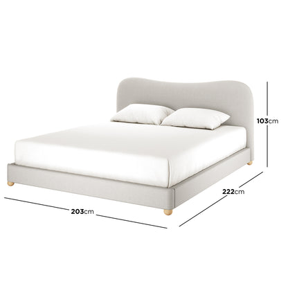 Ginnie Curved Linen Fabric Cloud Bed Frame - Grey King features a low-profile design with a gently curving headboard, upholstered in grey linen, supported by short round wooden legs, dressed in white bedding.