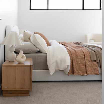 Ginnie Queen Curved Bouclé Cloud Bed Frame in Cream White, featuring a plush curved headboard and elegant bouclé fabric, set in a minimalist bedroom with neutral linens and a light taupe carpet.