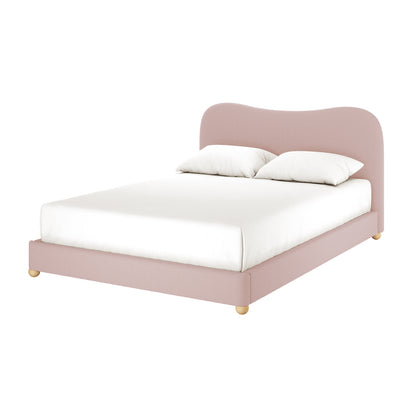 Ginnie Queen Curved Bouclé Cloud Bed Frame in Pink features a modern platform design with a blush-pink upholstered headboard, matching side rails, white mattress, pillows, and wooden legs, offering luxurious comfort.