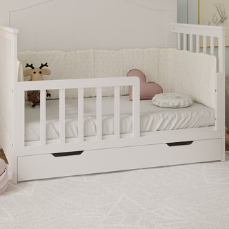 Giro Solid Pine Toddler Bed Rail Kit in White, featuring slatted side rails and a low front guard, with plush deer, pink heart cushion, and patterned pillow on the mattress.