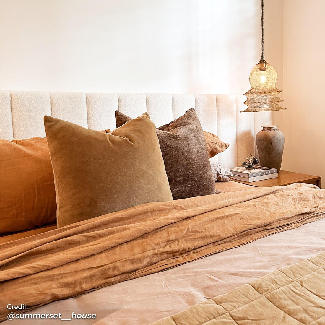 Aquila King Extra Wide Bouclé Headboard in Cream White, featuring a vertically-channeled design, plush bouclé fabric, and extra-wide structure, complements the cozy bedroom setting with its luxurious presence.