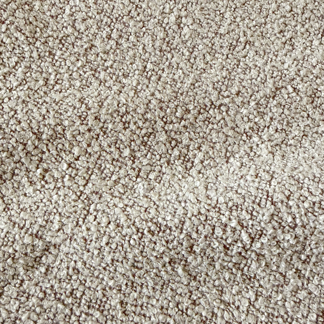 Close-up of warm beige boucle fabric texture with woven looped yarn pattern